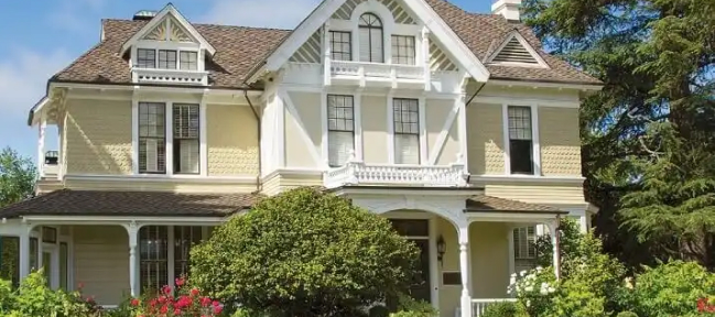 Sutter Home property's beautiful yellow with white trim VIctorian mansion in front of a bright blue sky