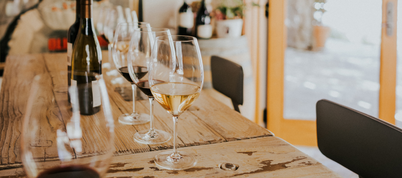 Wine glasses set up on a wooden table inside the Neyers tasting room.