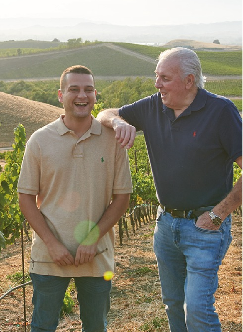 Protege winemakers Mike Chelini and Mathew Torres in the vineyard laughing with each other