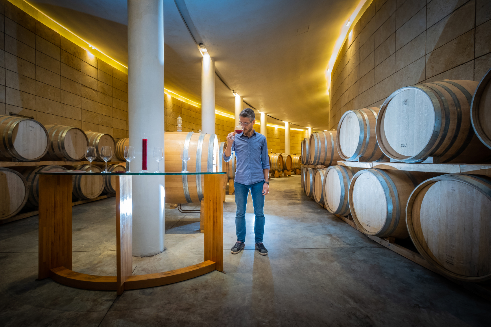 San Polo winemaker Riccardo Fratton tasting wine in the modern barrel room of San Polo wines
