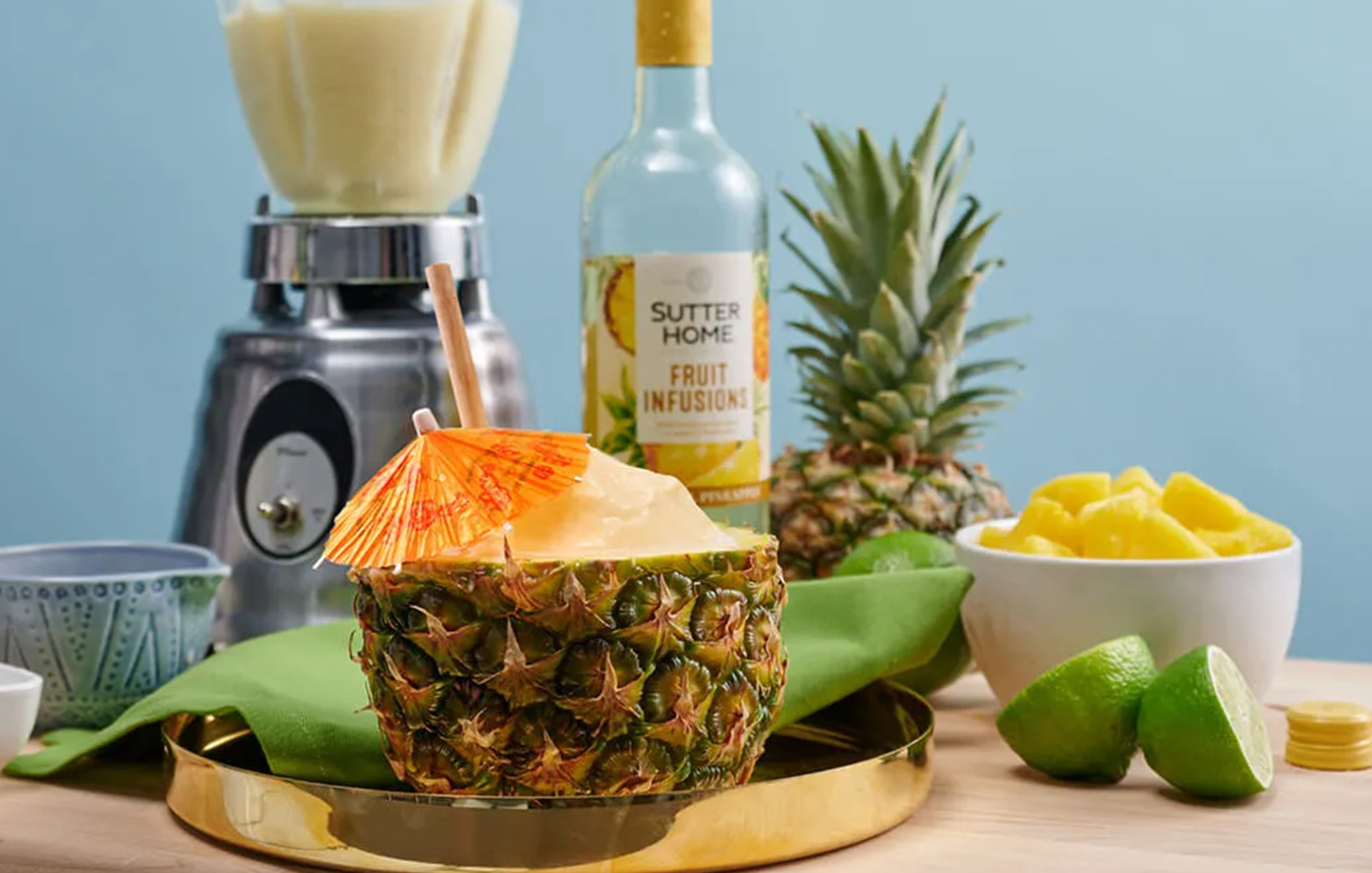 Wine cocktail served in a pineapple made with Sutter Home fruit infusions pineapple.