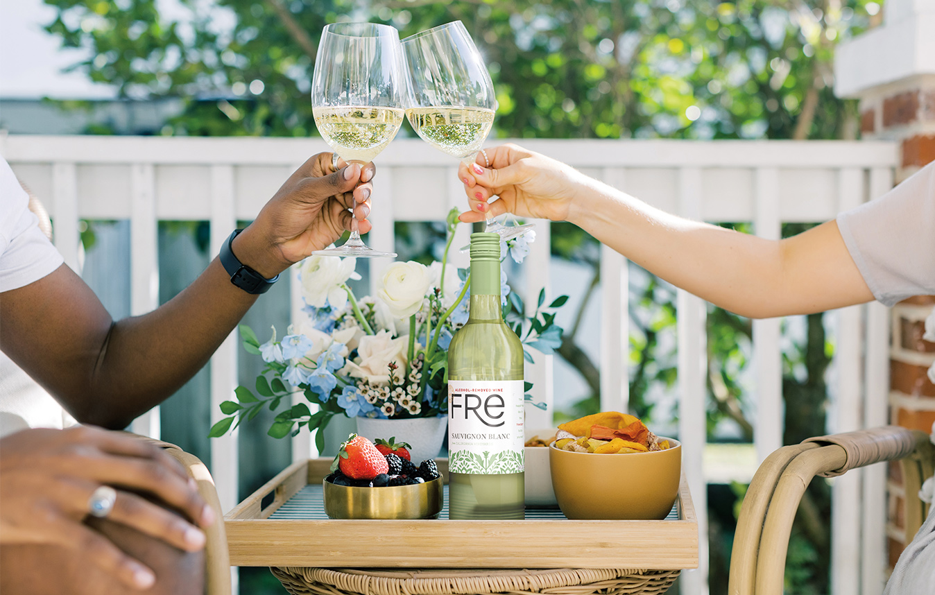 Couple on a deck on a beautiful day cheersing glasses of FRE Sauvignon Blanc