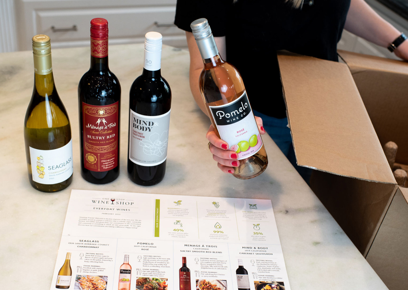 person unboxing and everyday wine club shipment from one stop wine wine shop wine club