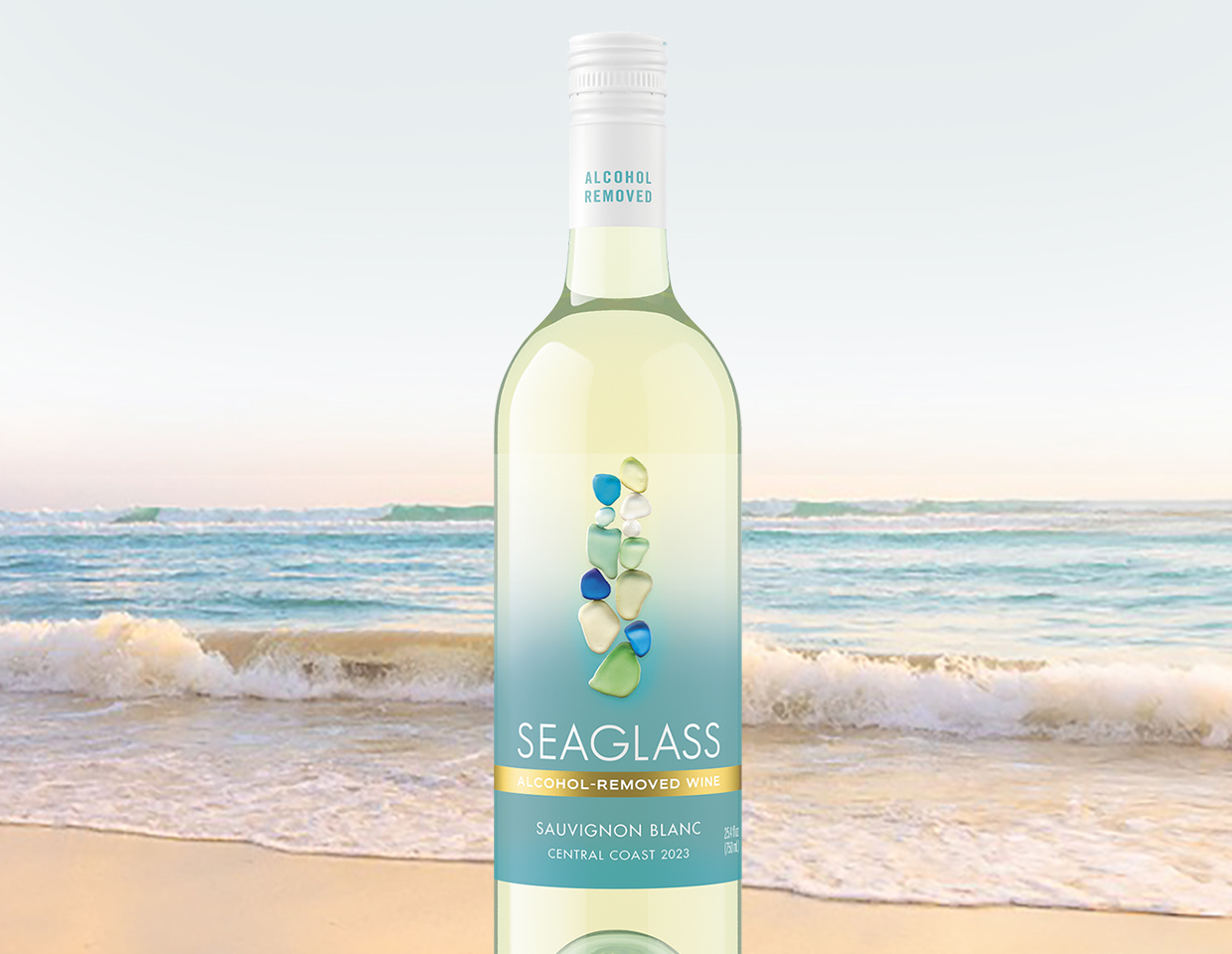 bottle of SEAGLASS alcohol-removed sauvignon blanc with ocean waves cresting onto a beach