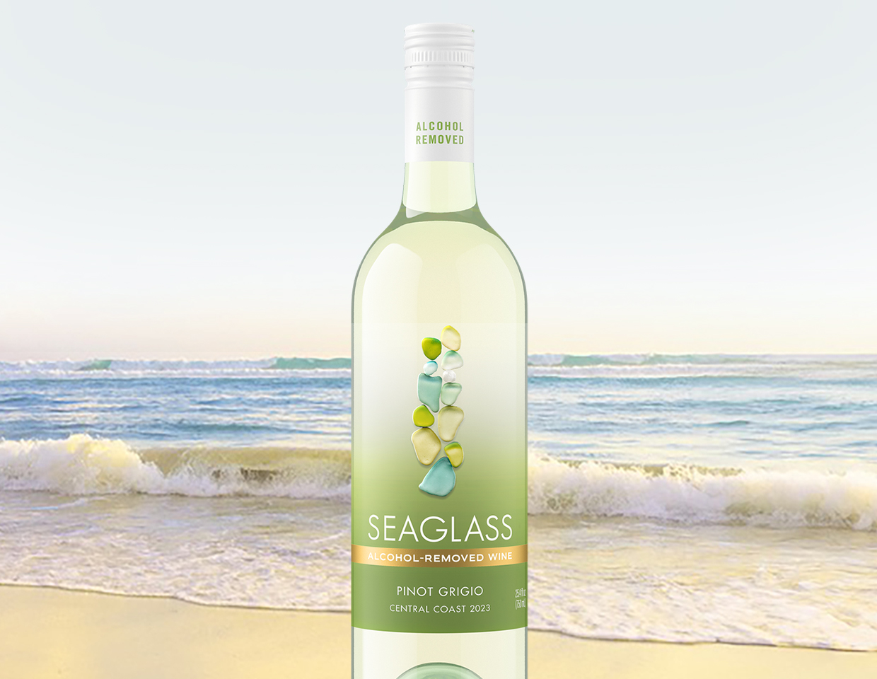 bottle of SEAGLASS alcohol-removed pinot grigio with ocean waves cresting onto a beach