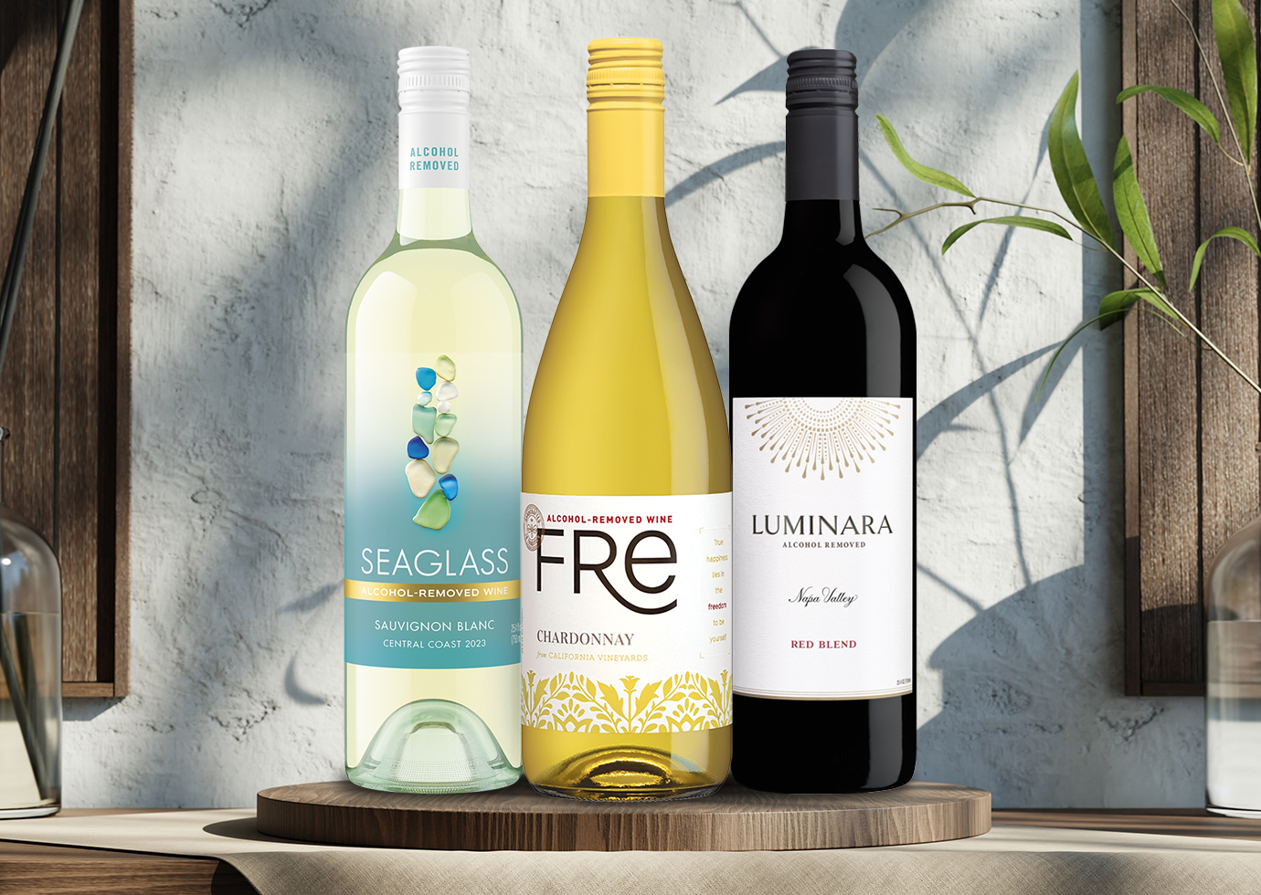 bottles of SEAGLASS alcohol-removed sauvignon blanc, FRE alcohol-removed chardonnay, Luminara alcohol-removed red blend on a wooden board on a counter