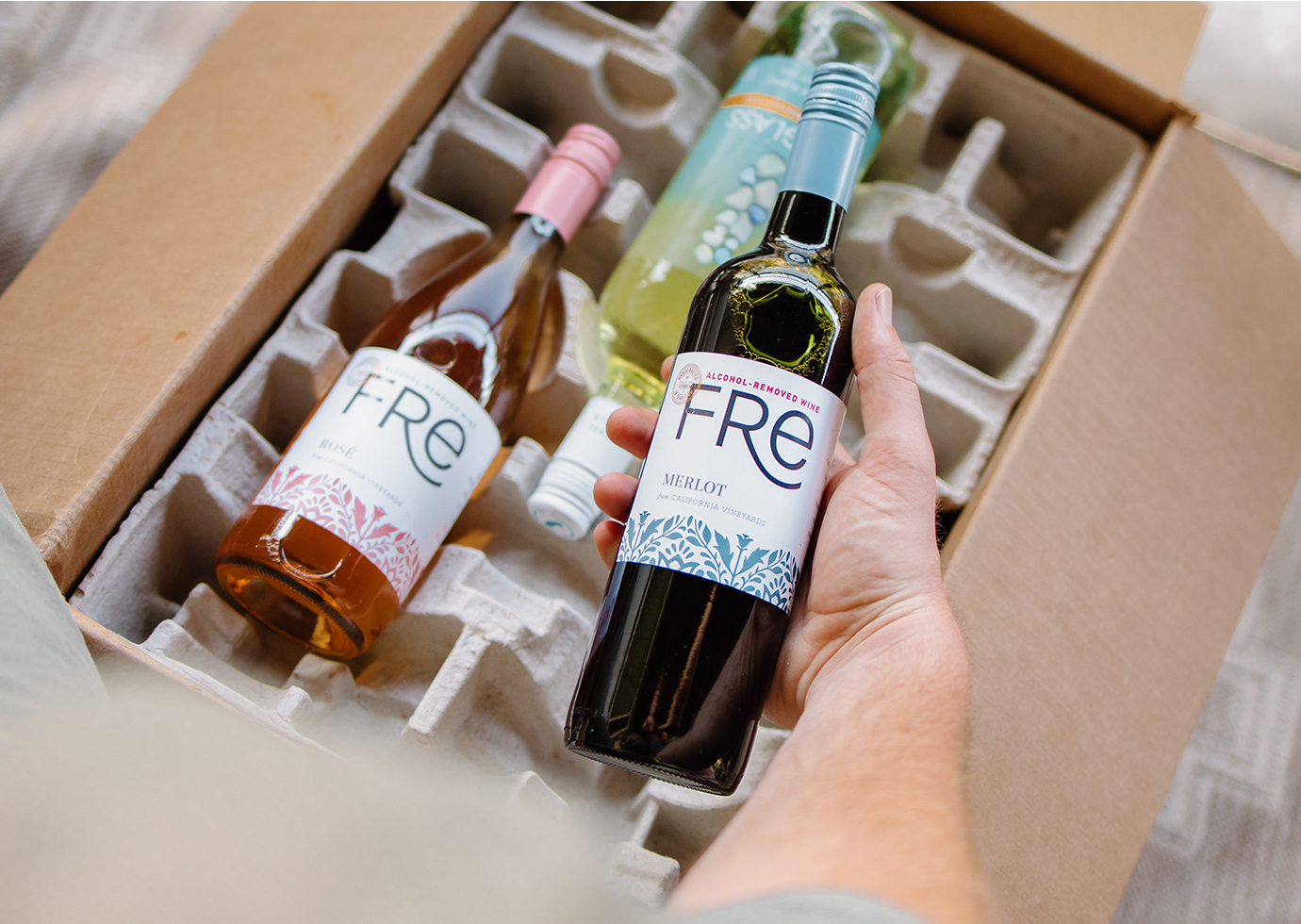 person unboxing an alcohol-removed wines club shipment from One Stop Wine Shop