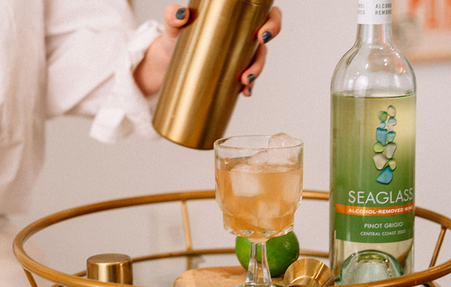 woman mixing up a paloma mocktail made with SEAGLASS alcohol-removed pinot grigio