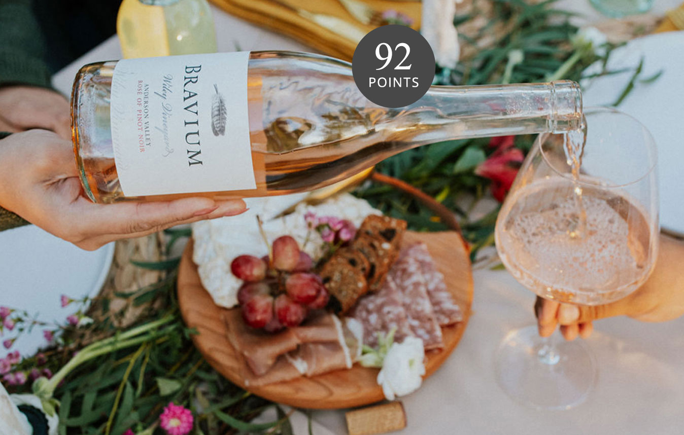 pouring a glass of Bravium rose at a spring table, rated 92 points