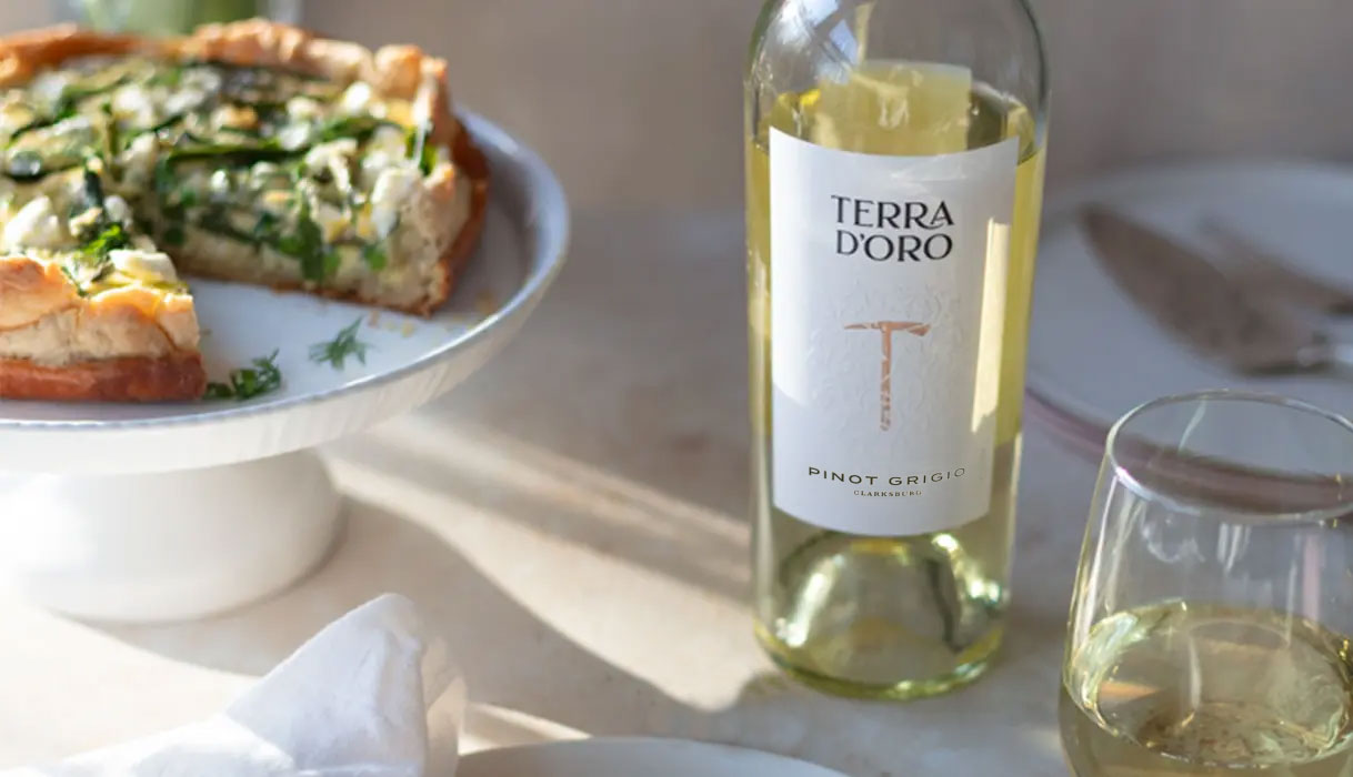 A bottle and glass of Terra d'Oro pinot grigio paired with a veggie quiche. Get this recipe and more from One Stop Wine Shop