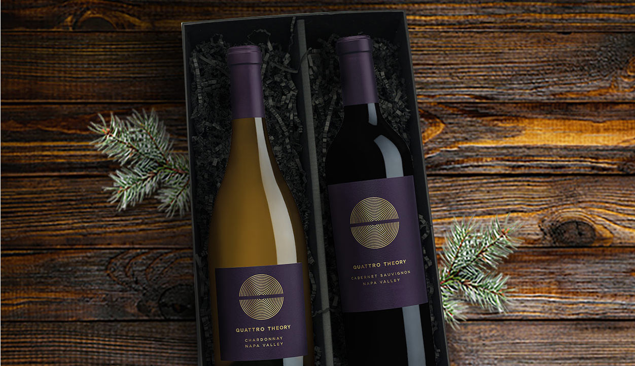 Quattro Theory gift set featuring Quattro Theory Chardonnay and Cabernet Sauvignon in a black gift box on a wooden table. Shop One Stop Wine shop for wine gift sets.