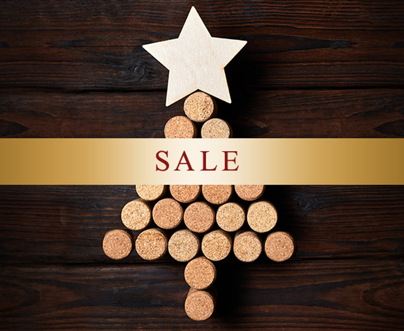A Christmas tree made out of corks with a shiny gold banner with the word sale on it. Shop sale wines at One Stop Wine Shop.