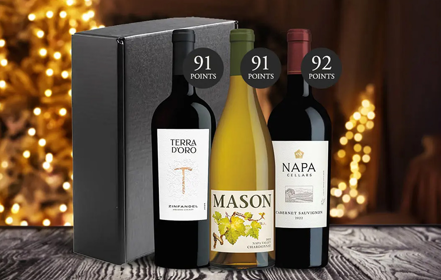The top-scoring holiday trio wine gift set in front a brightly lit Christmas tree. Shop this wine gift set and more from One Stop Wine Shop.