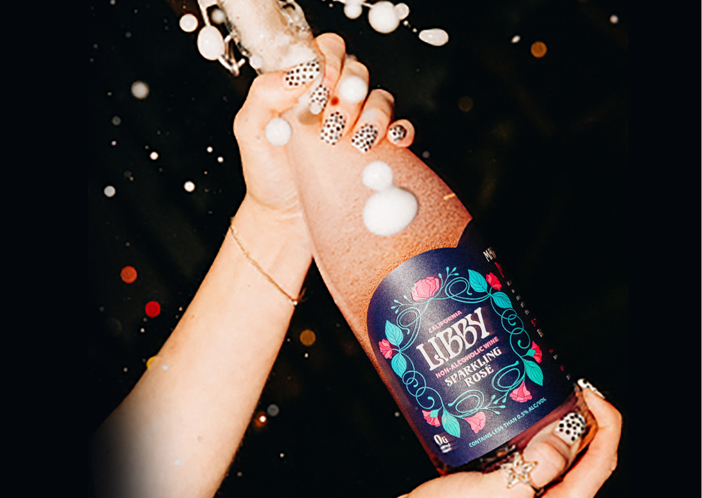 person popping open a bottle of Libby non-alcoholic wine