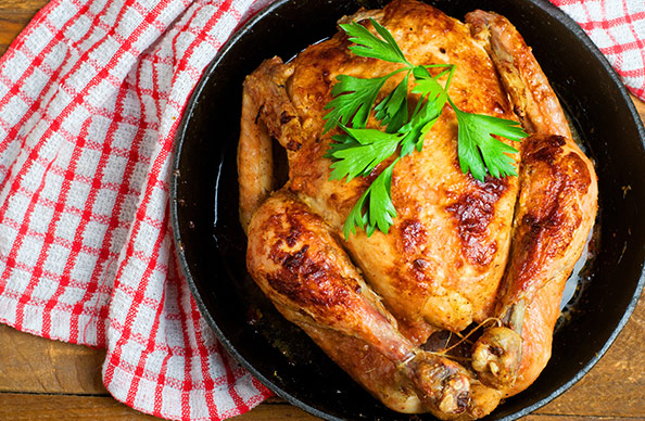 http://A%20whole%20roast%20chicken%20in%20a%20cast%20iron%20pan%20garnished%20with%20parsley
