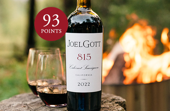 Bottle of Joel Gott 815 Cabernet Sauvignon, rated 93 points, in front of a campfire. Shop this top scoring wine and more at One Stop Wine Shop.